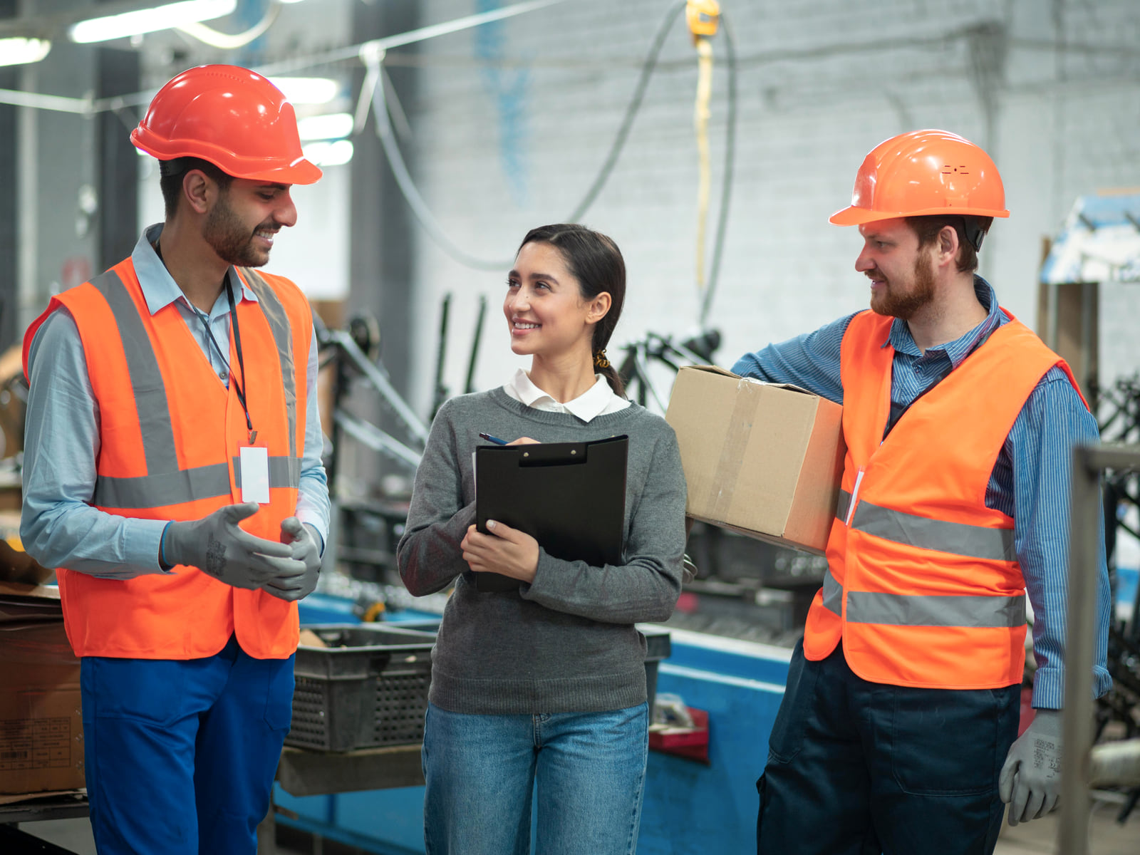 A small group of Indian workers in a modern production environment with a coordinator